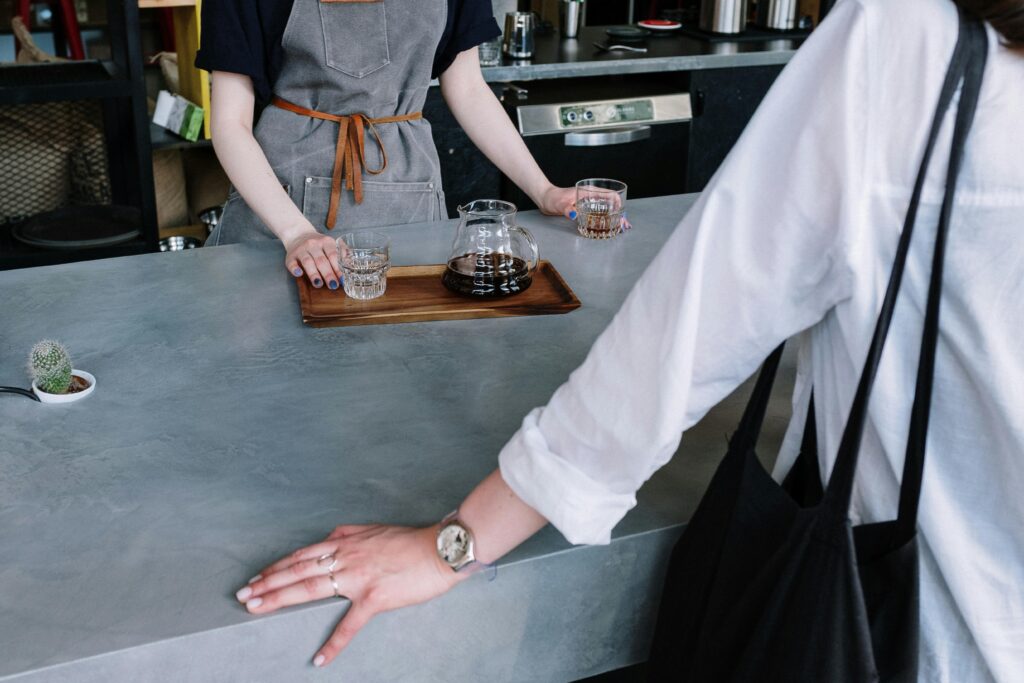 A barista presents a customer with high-end pour-over coffee in a coffee shop 