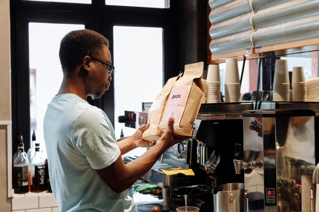 A barista compares two bags of coffee in front of a brewing station