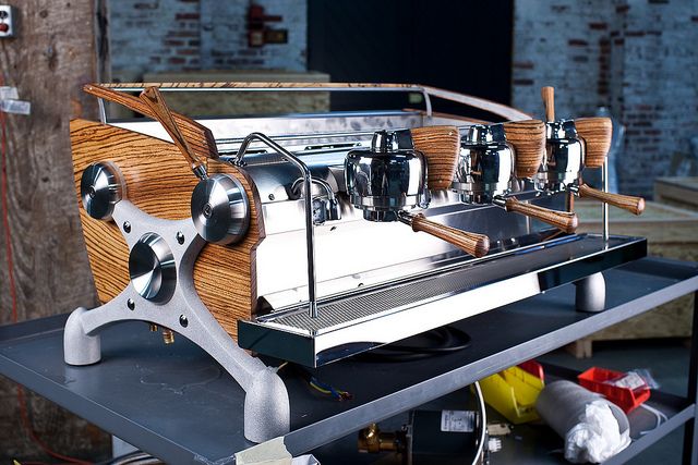 A Slayer espresso machine with chrome and wood features looks beautiful in a new coffee shop
