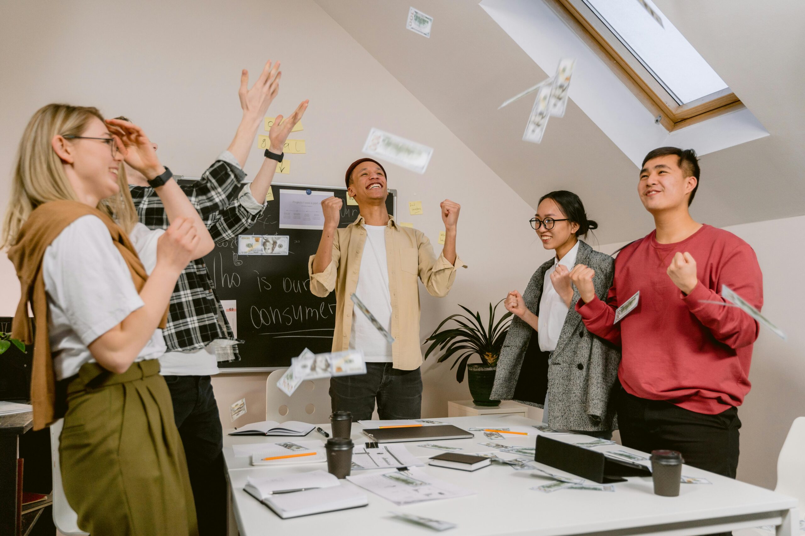 A group of five employees celebrating at the office as they leave for a company coffee event